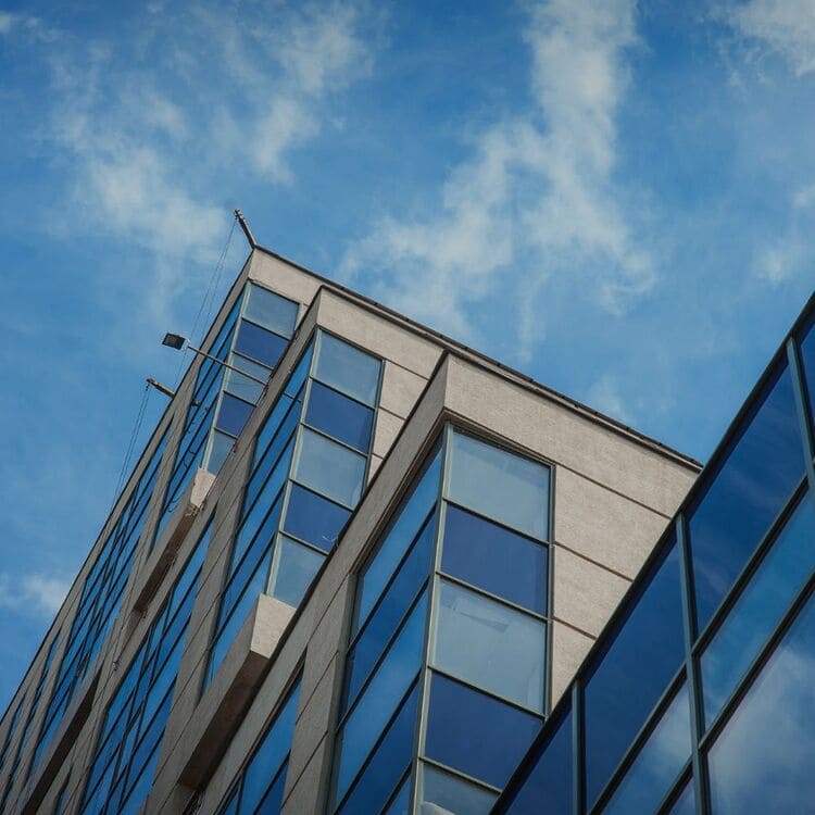 Modernes Bürogebäude eines IT-Dienstleisters mit Glasfassade und blauem Himmel